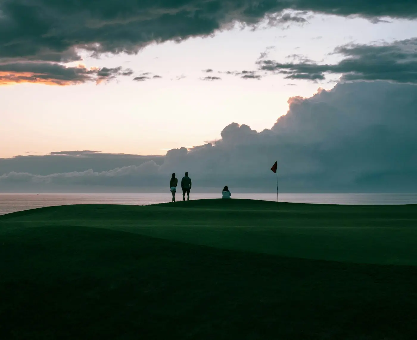 Two golfers on a green at sunset